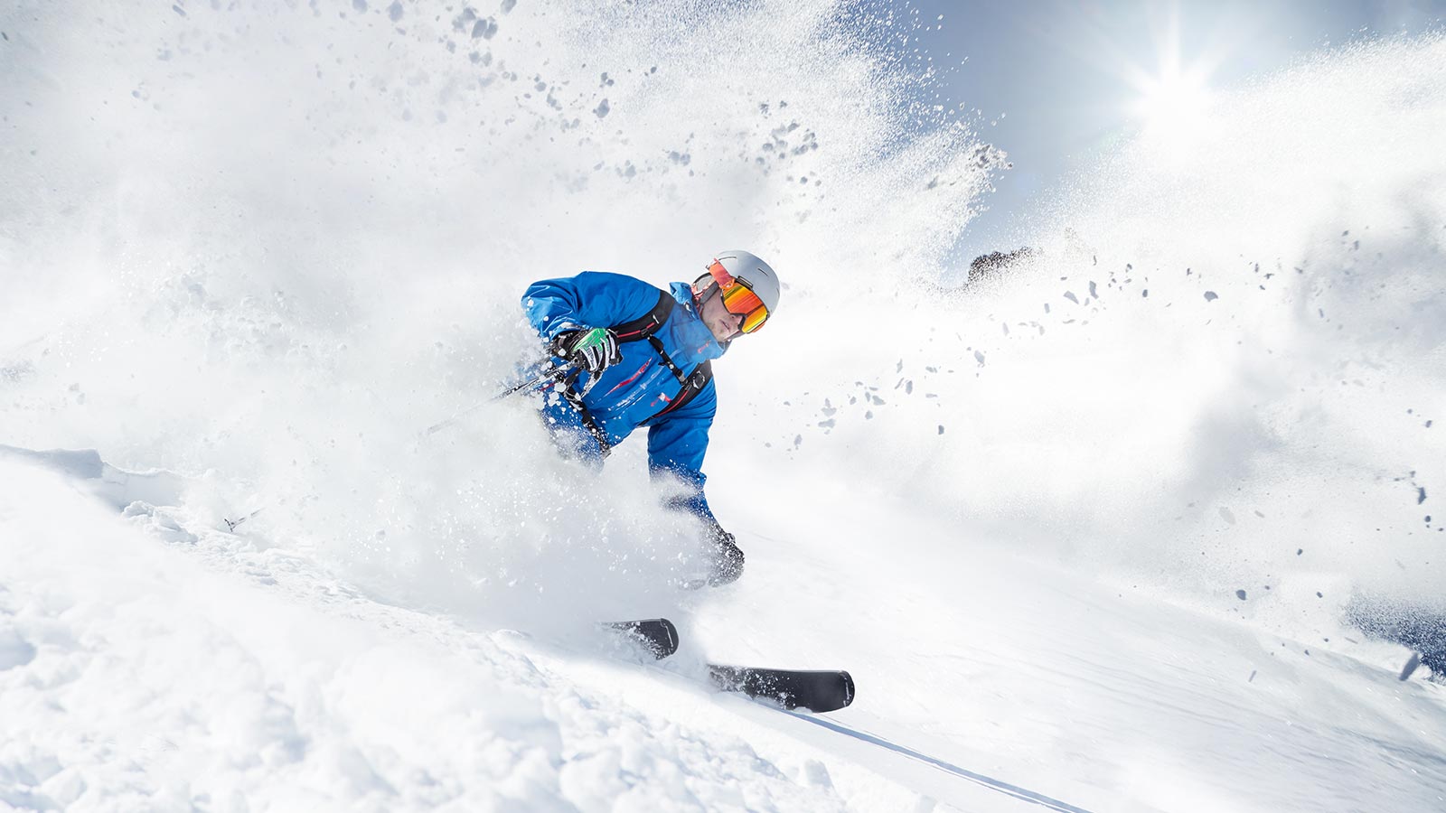 Skifahrer fährt die Piste hinunter in Alta Badia an einem sonnigen Tag